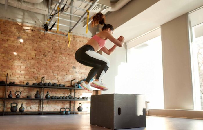 Schnellkrafttraining. Frau springt auf eine Box