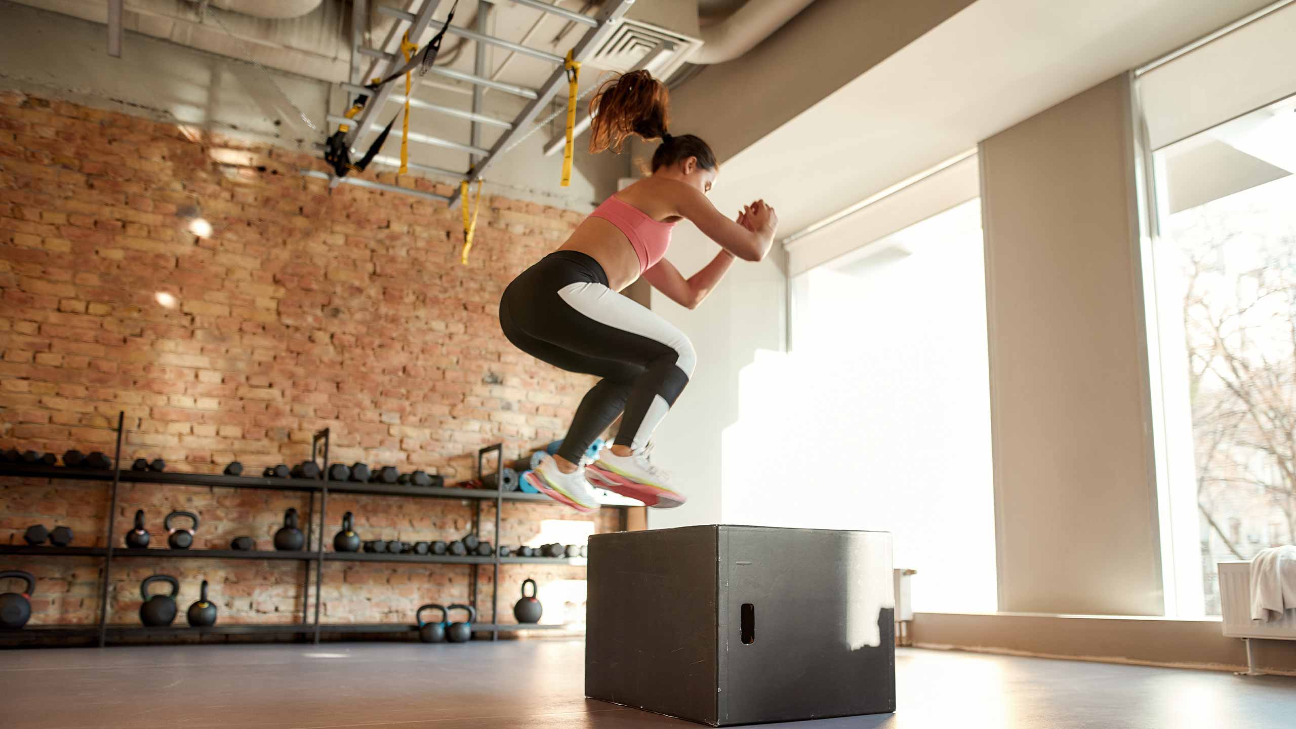 Schnellkrafttraining. Frau springt auf eine Box