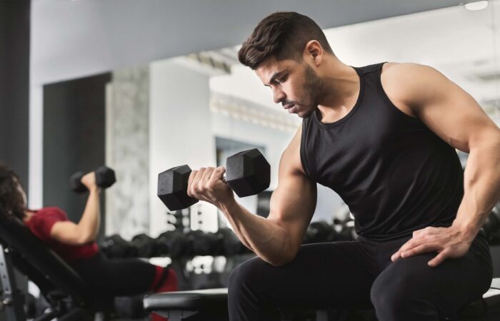 Mann der Bizeps trainiert im Fitnesstudio balance